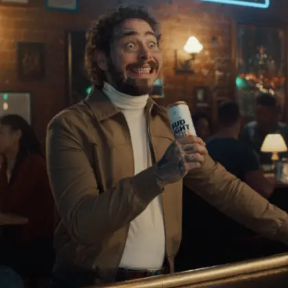 Man in bar smiling while holding beer