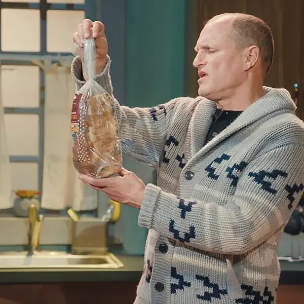 Actor holding a packed bread in the kitchen