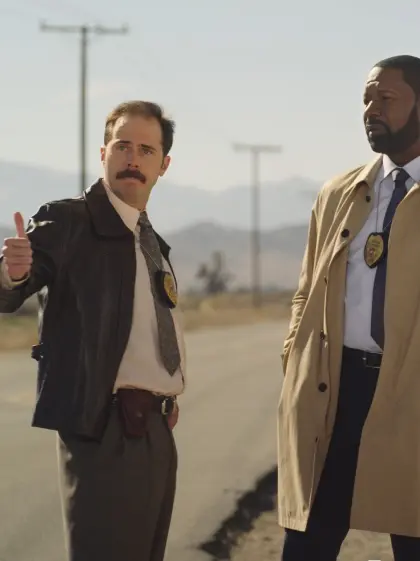 Two cops in desert looking towards the camera